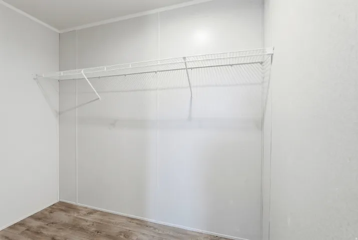 Walk in closet with light wood-style flooring