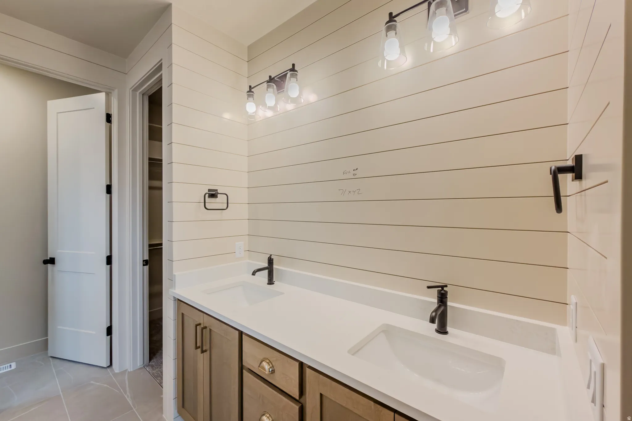 Full bath with double vanity and light tile patterned flooring