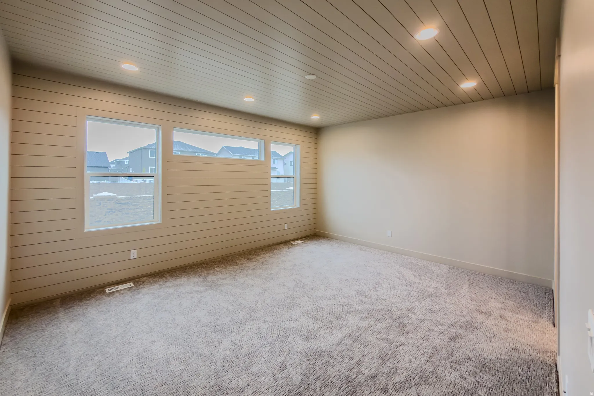 Unfurnished room with wooden ceiling, carpet, recessed lighting, and wood walls