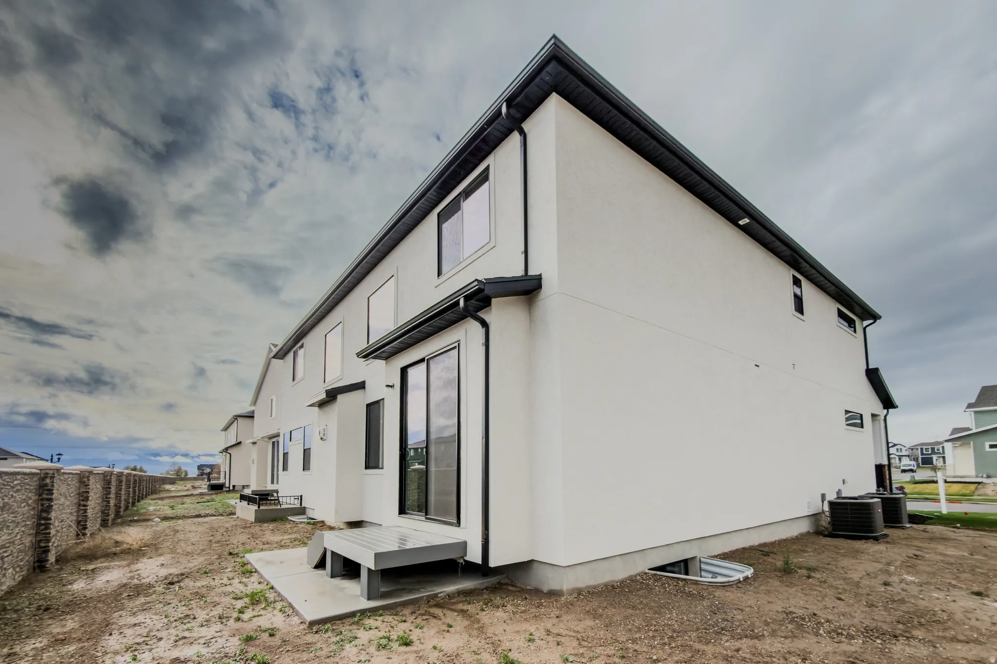 View of side of property featuring stucco siding and a cooling unit