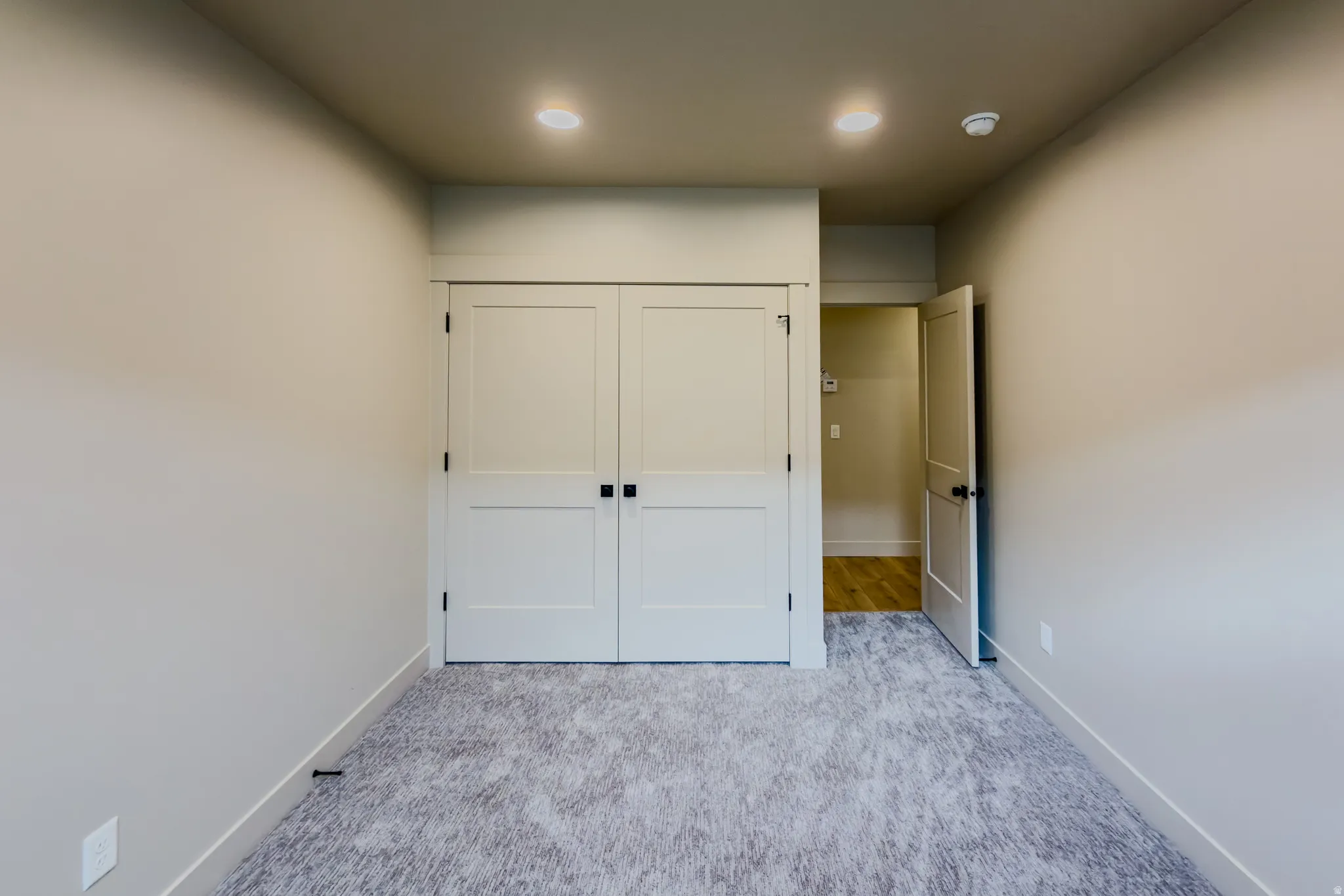 Unfurnished bedroom featuring light carpet, a closet, and recessed lighting