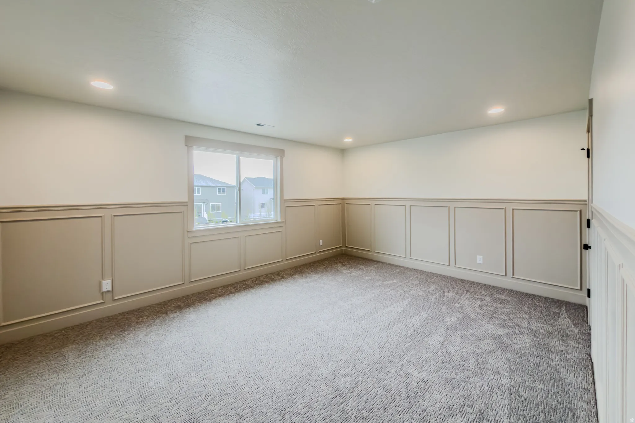 Unfurnished room featuring wainscoting, a decorative wall, recessed lighting, and light colored carpet