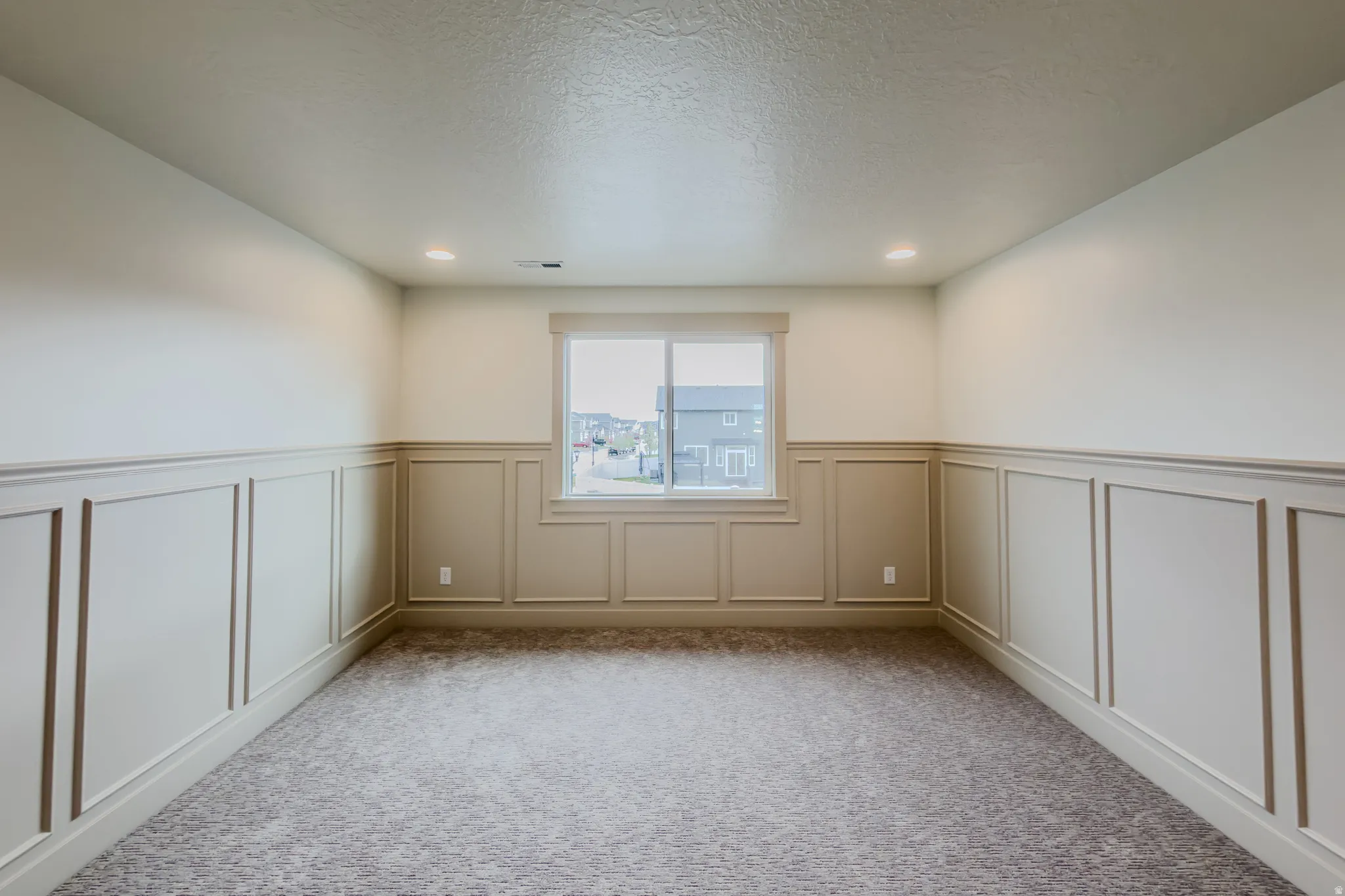Carpeted spare room with a wainscoted wall, a decorative wall, and recessed lighting