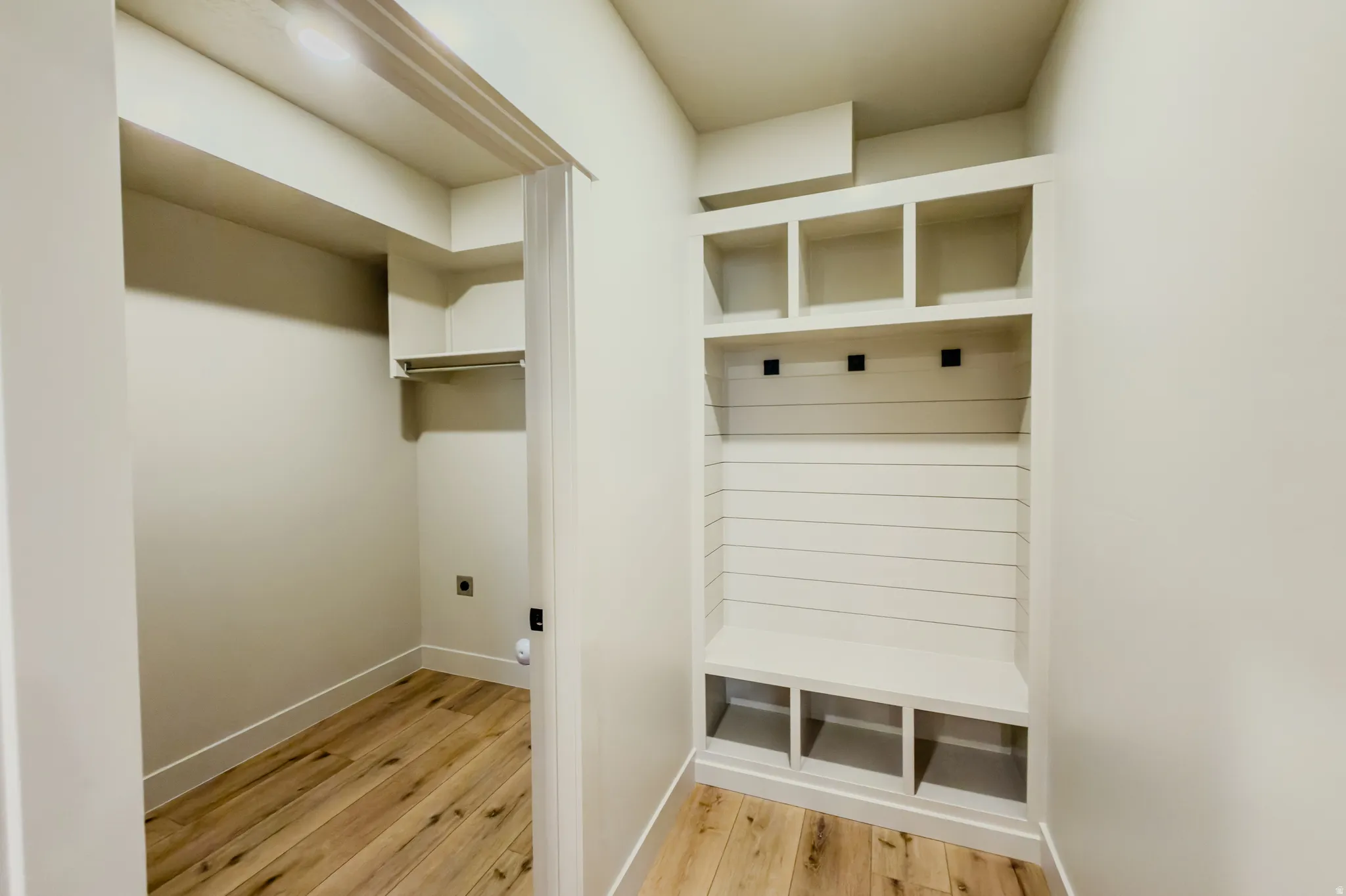 Mudroom featuring light wood-style flooring and baseboards