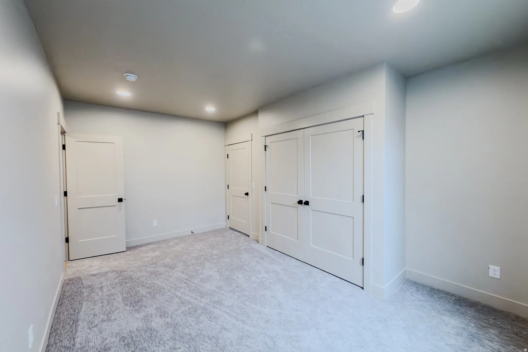 Unfurnished bedroom with light colored carpet, recessed lighting, and a closet