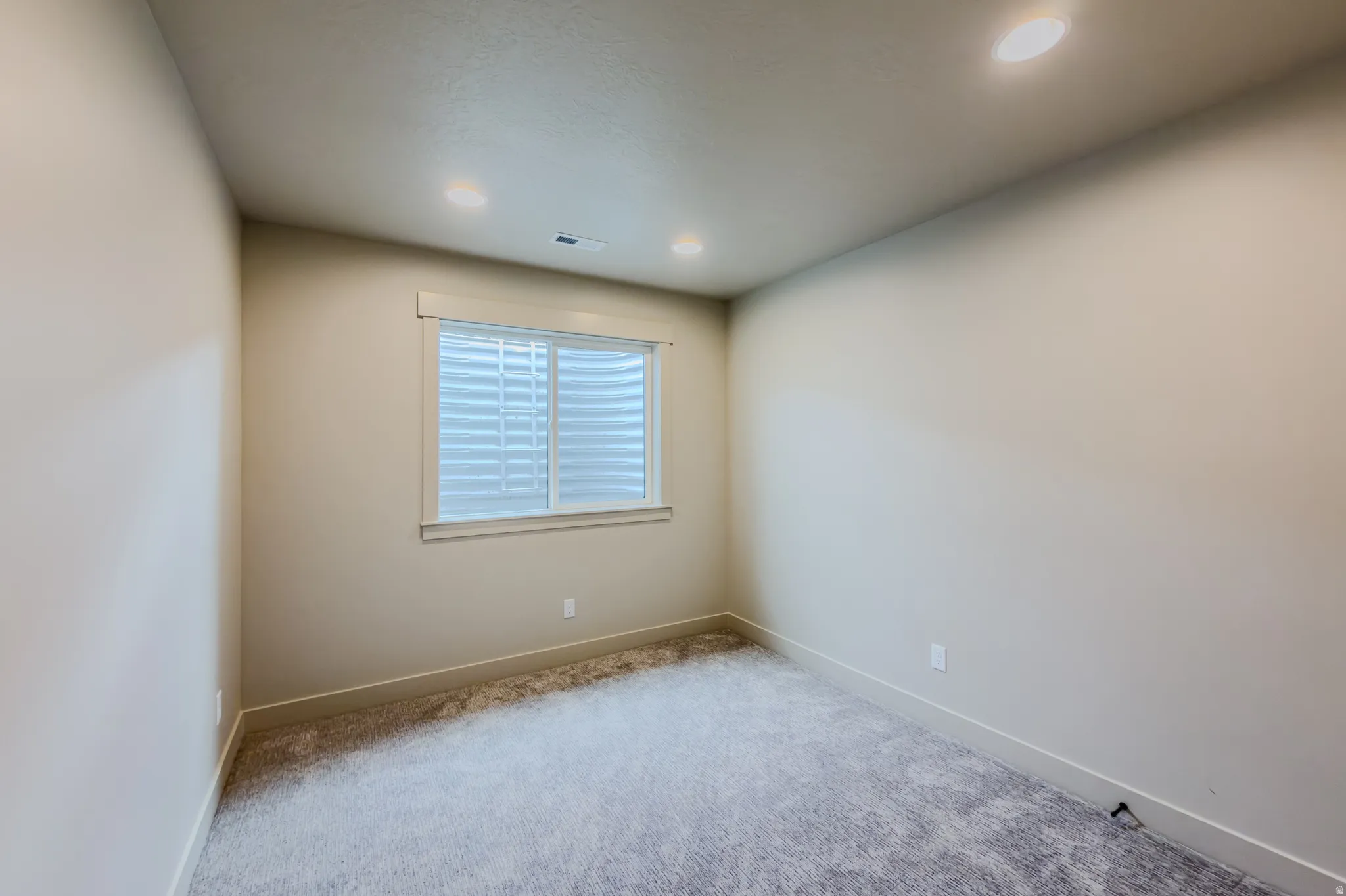 Spare room featuring light carpet and recessed lighting
