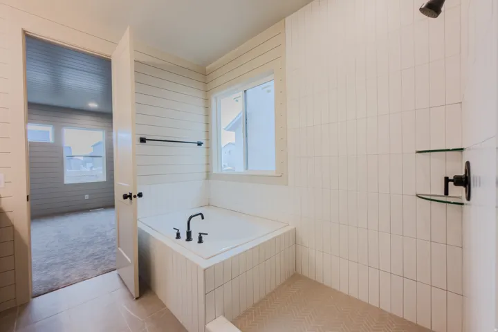 Full bathroom with a garden tub, light tile patterned flooring, and a tile shower