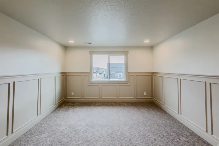 Carpeted spare room with a wainscoted wall, a decorative wall, and recessed lighting
