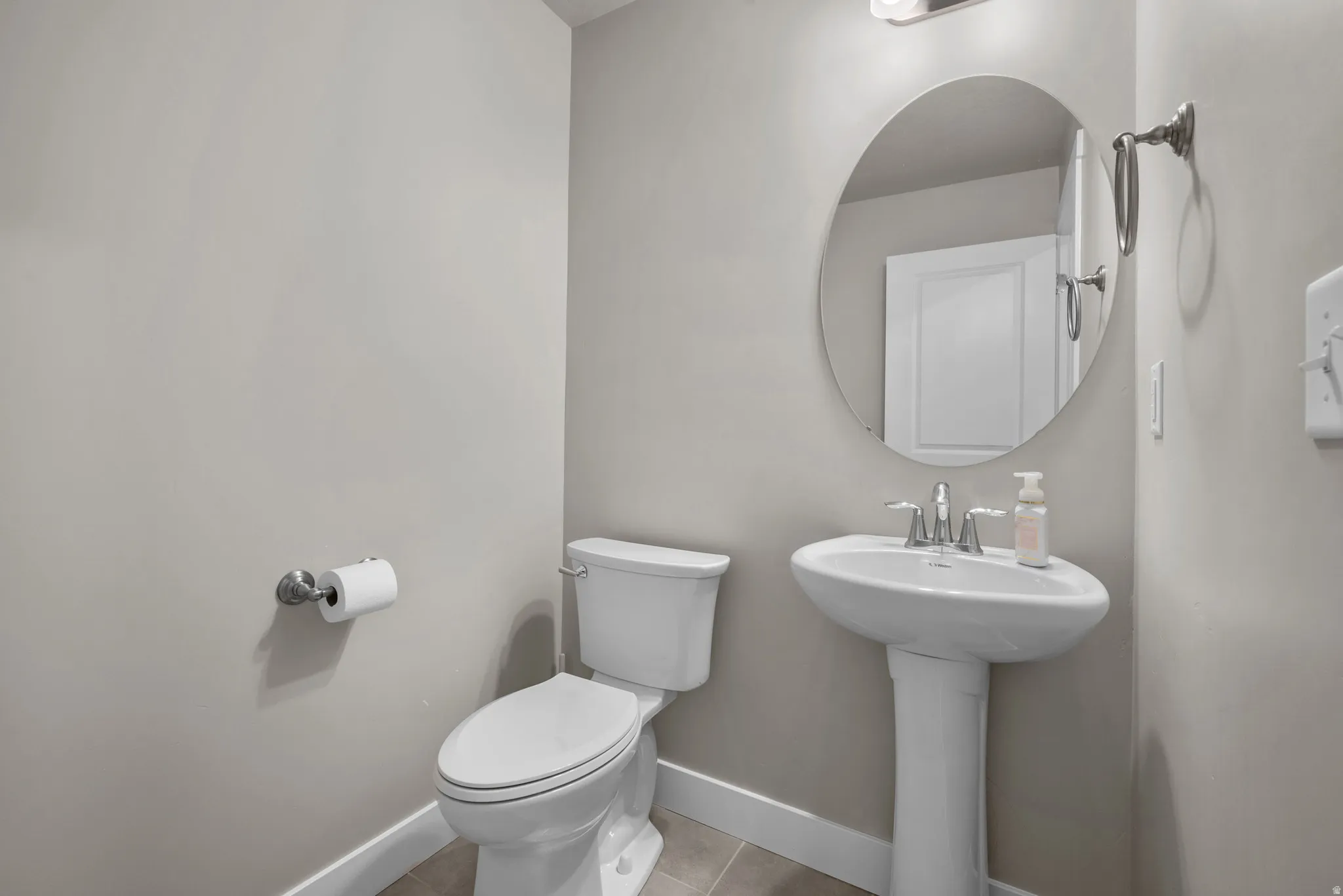 Half bathroom with toilet and light tile patterned floors