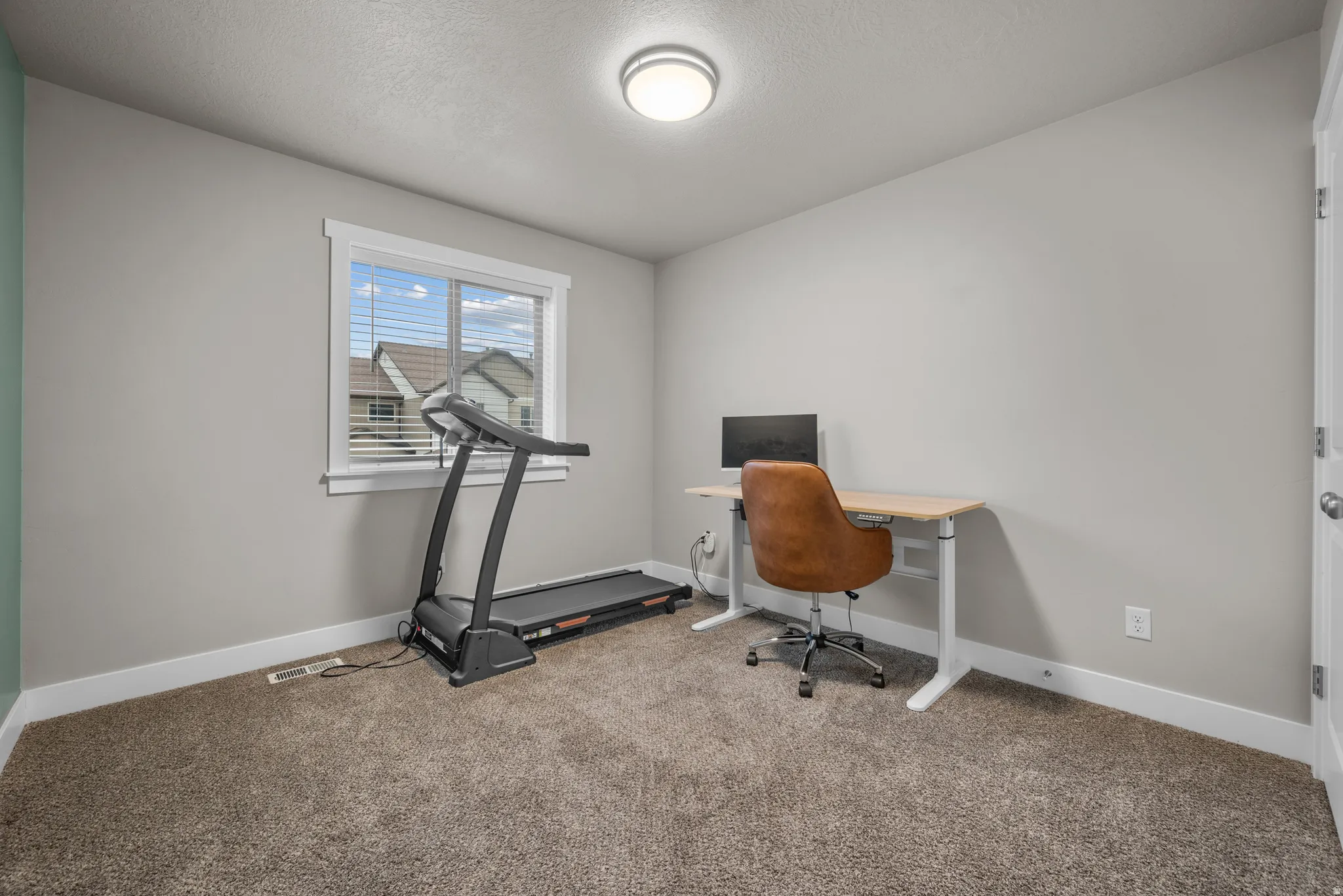 Office area with light carpet and a textured ceiling