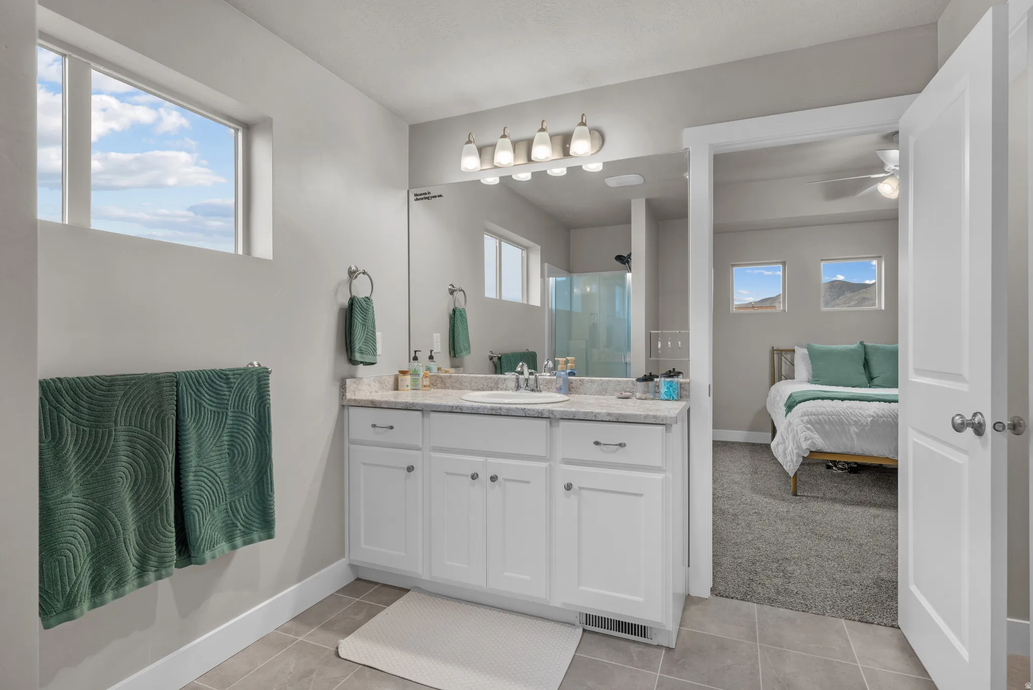Full bathroom featuring vanity, a shower stall, light tile patterned flooring, ensuite bathroom, and a ceiling fan