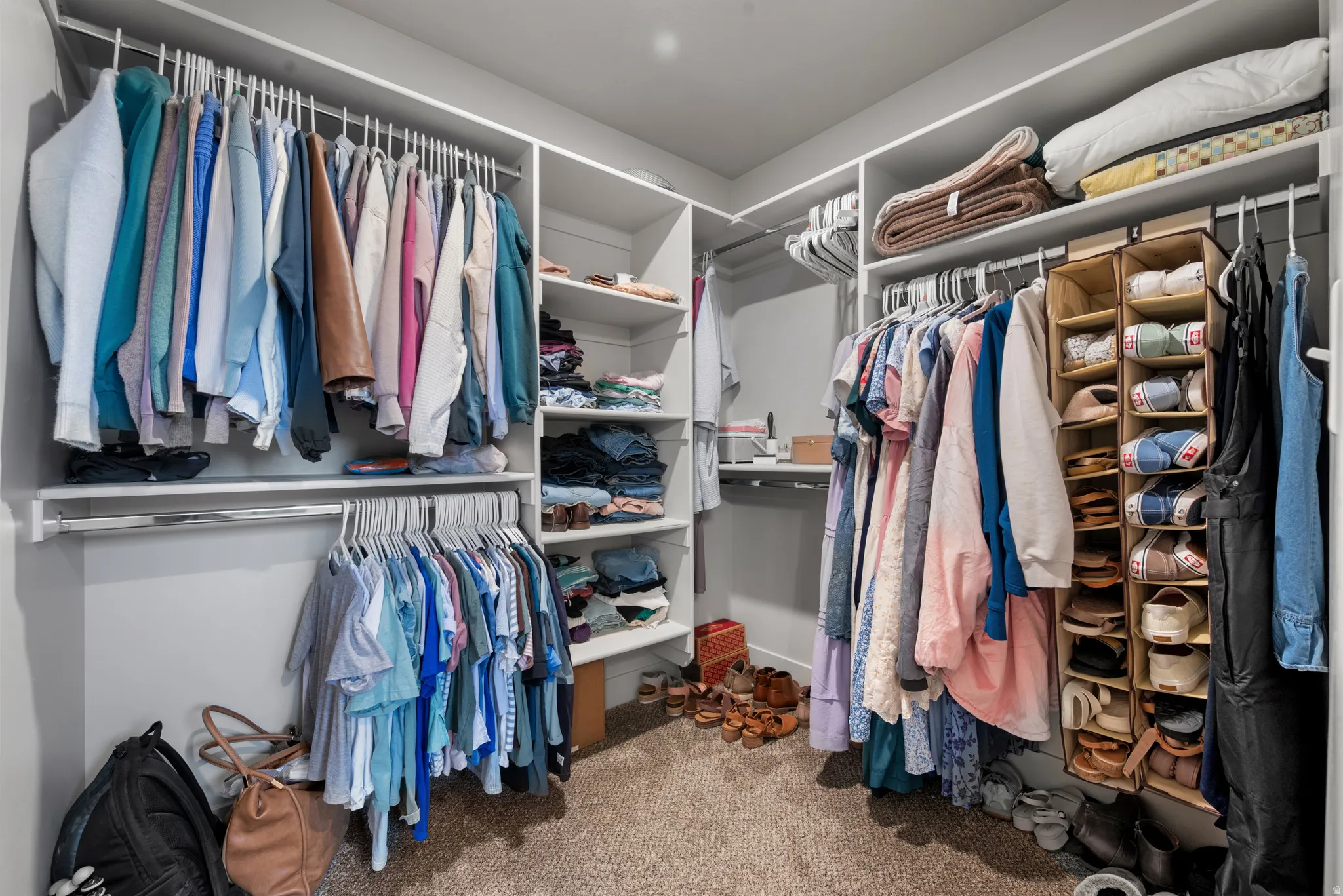 Walk in closet with light colored carpet