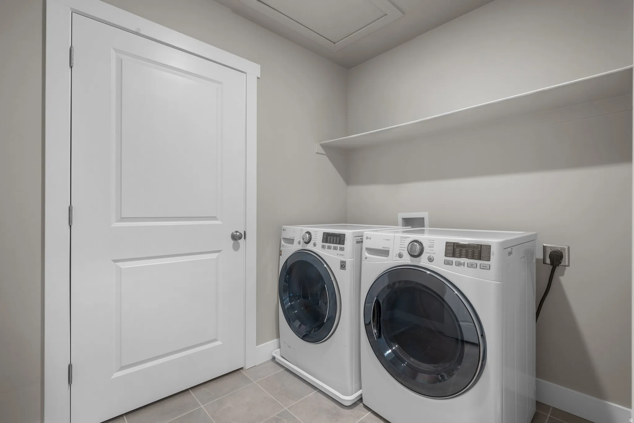 Laundry area featuring separate washer and dryer and light tile patterned floors