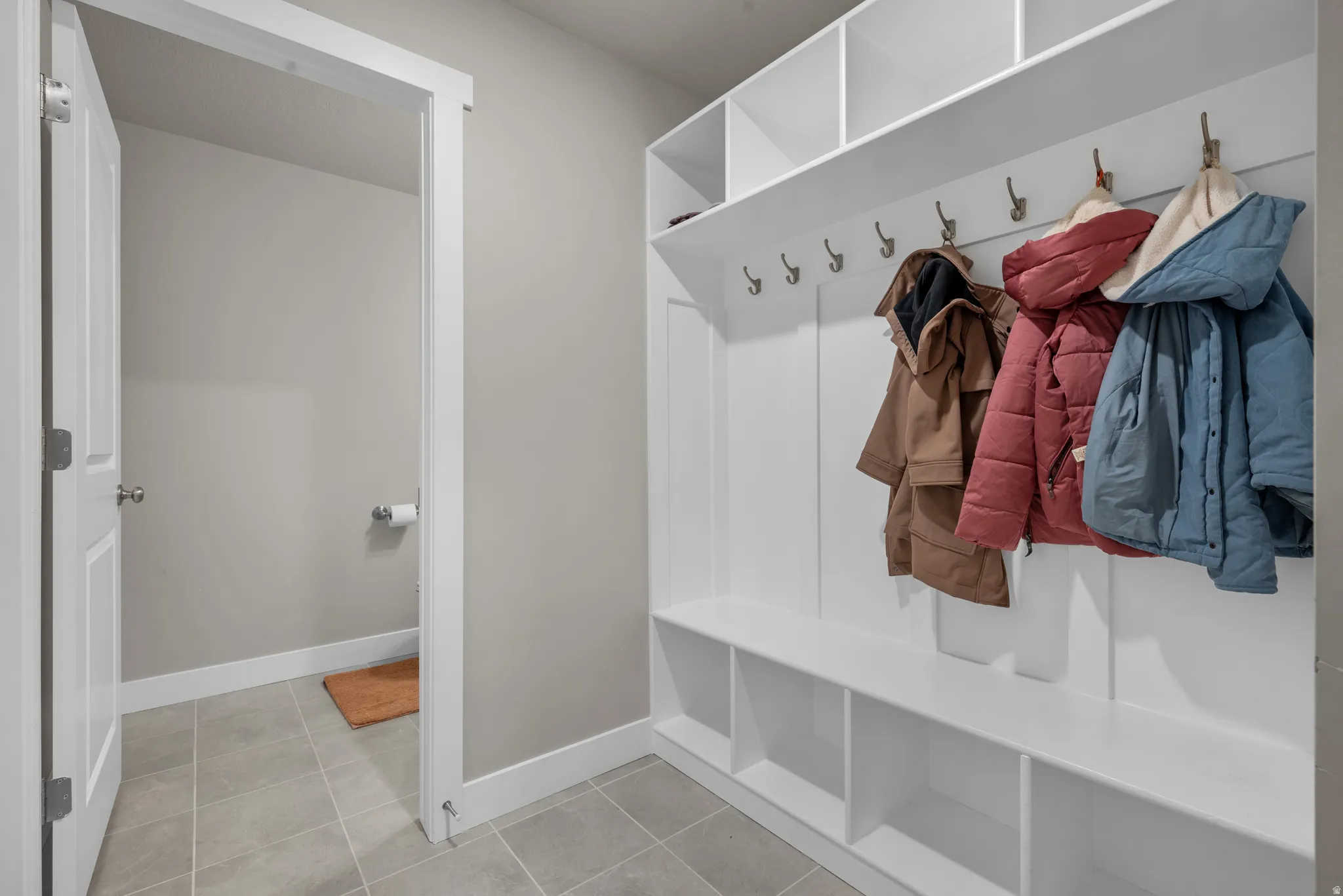 Mudroom with light tile patterned floors and baseboards