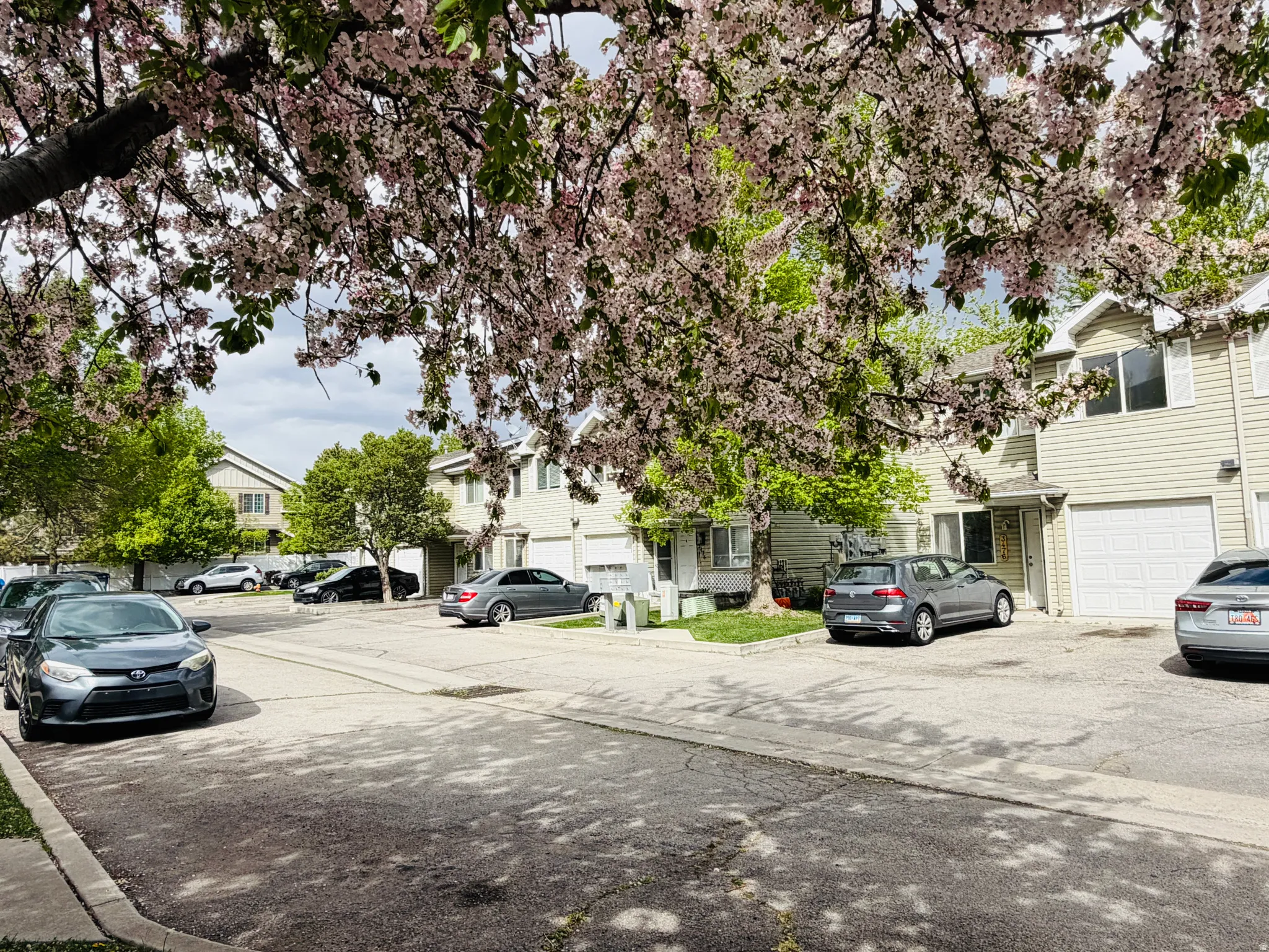 View of asphalt road with a residential view and curbs