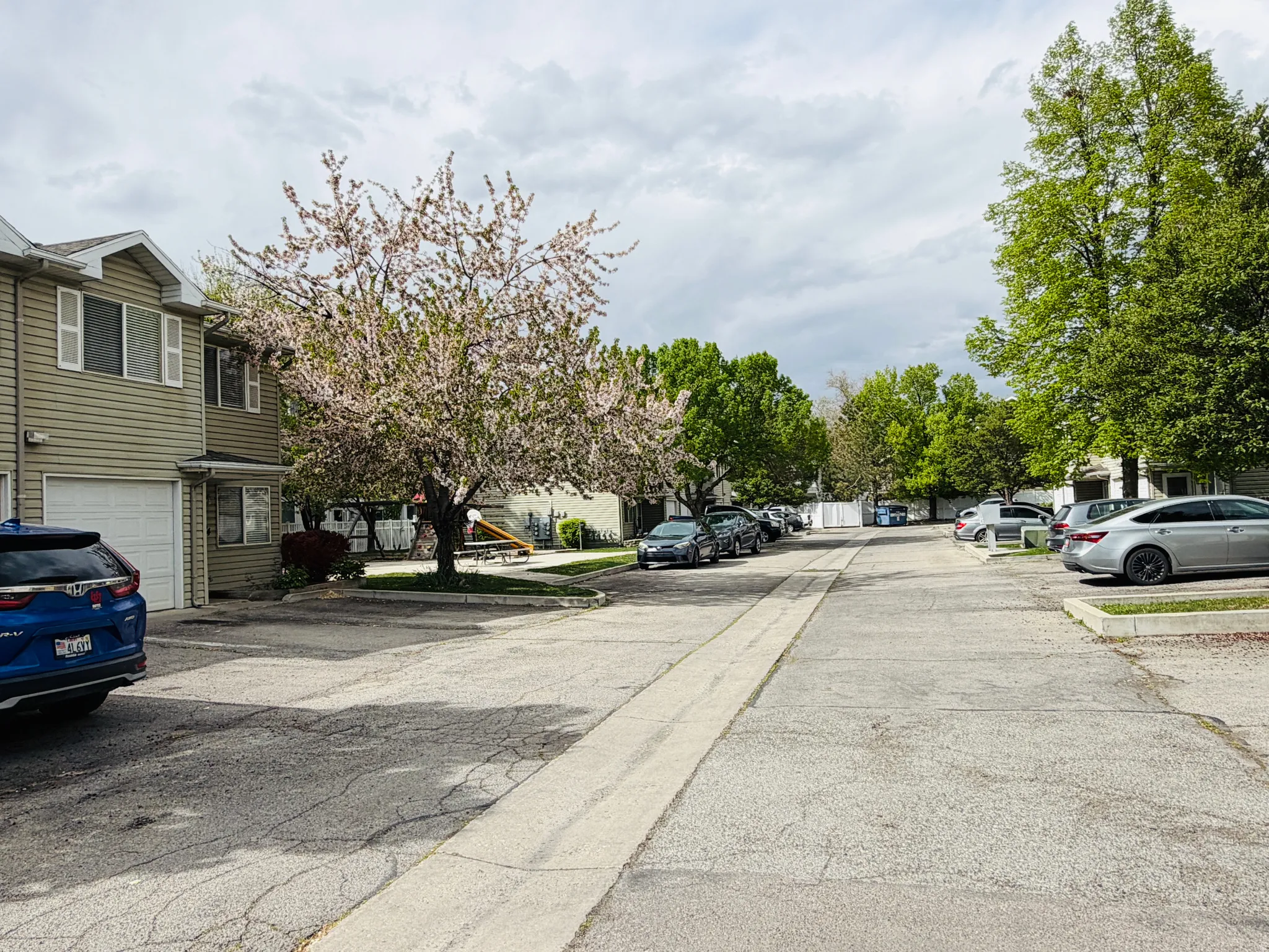 View of asphalt road with a residential view and curbs
