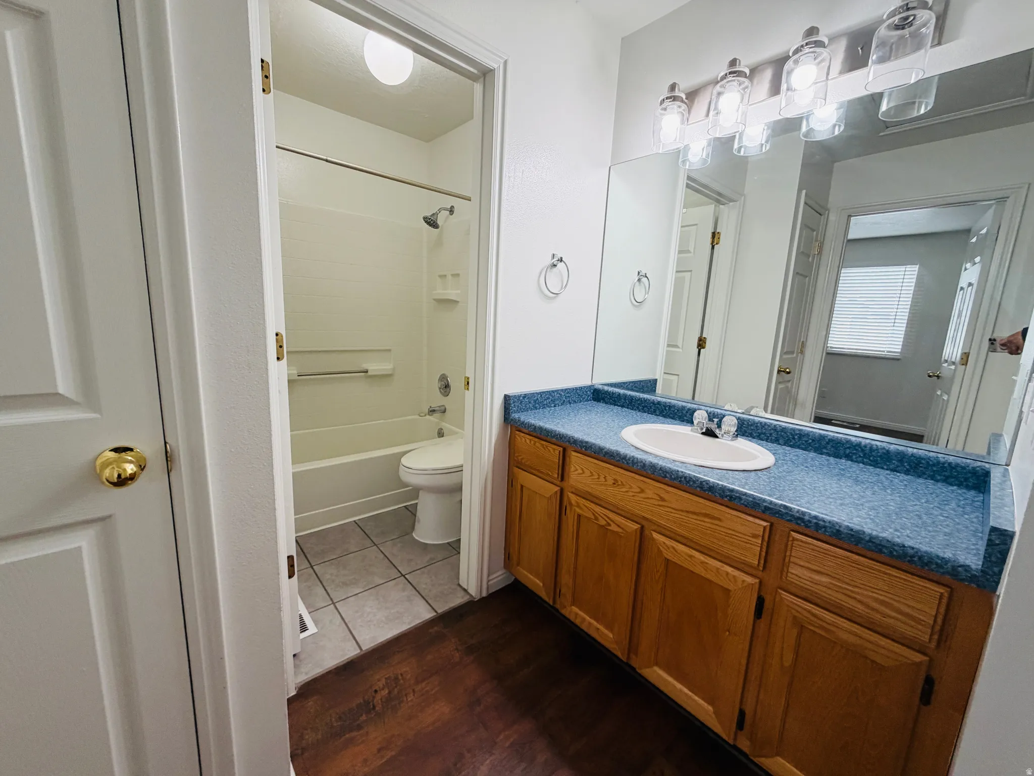 Bathroom featuring vanity, dark wood-type flooring, and shower / bath combination