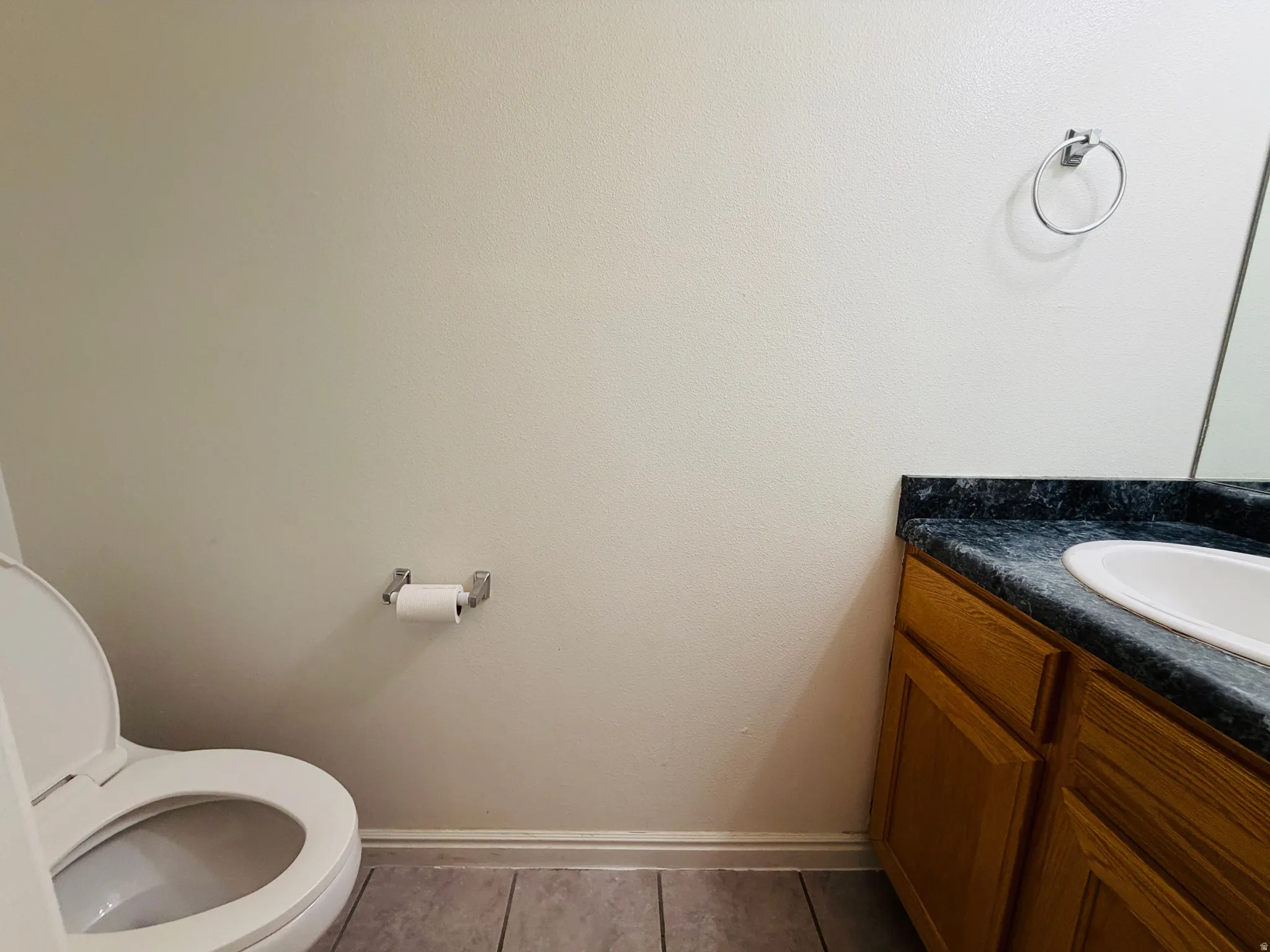 Bathroom with vanity and dark tile patterned flooring