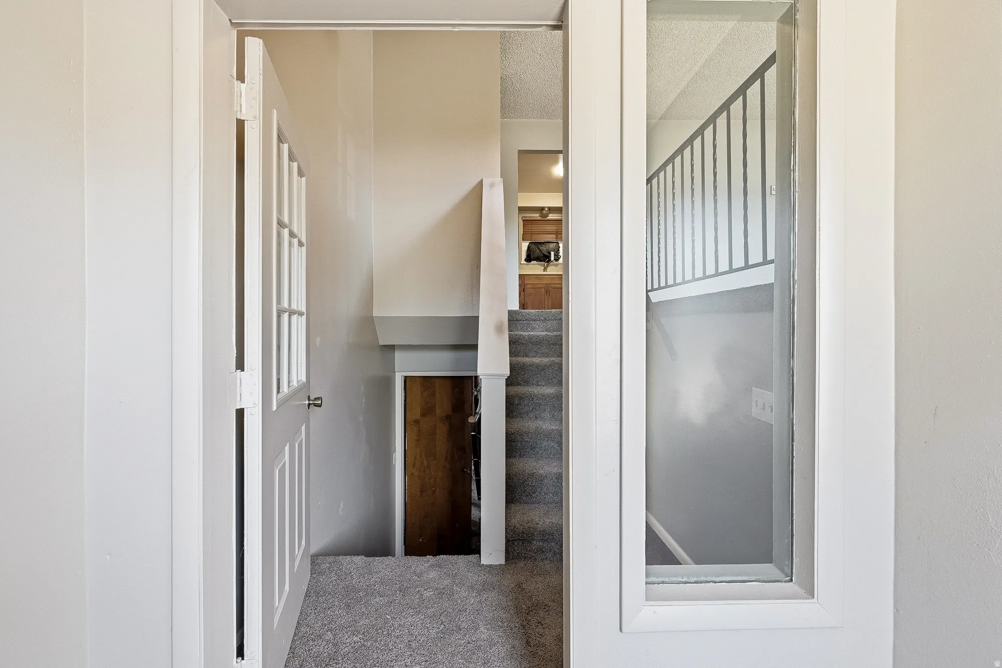 Staircase with carpet flooring and a textured ceiling