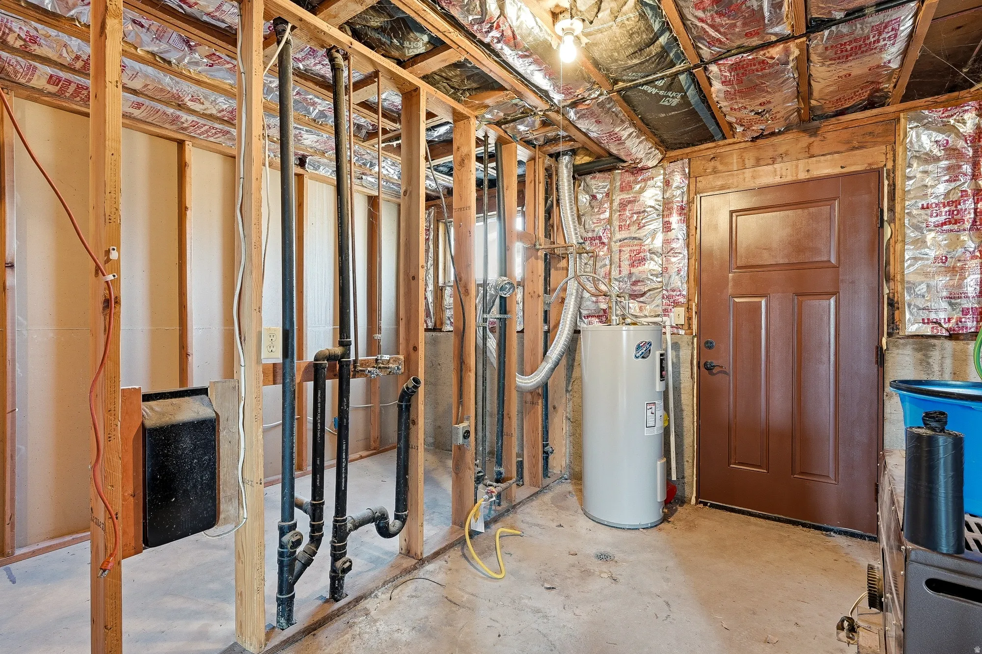 Unfinished below grade area featuring water heater