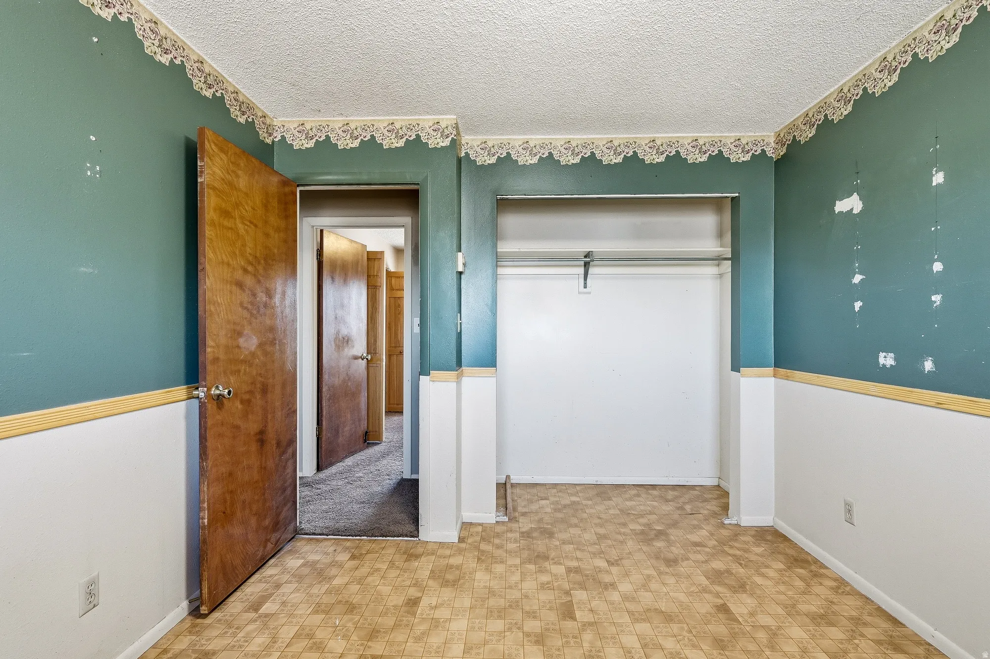 Unfurnished bedroom with a textured ceiling, tile patterned floors, and a closet