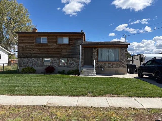 View of front of home featuring stone siding and a chimney