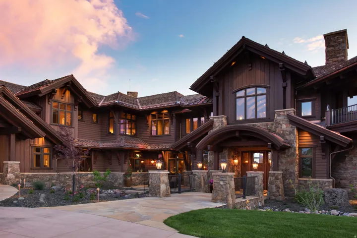 View of front facade with stone siding, a fenced front yard, a gate, and board and batten siding