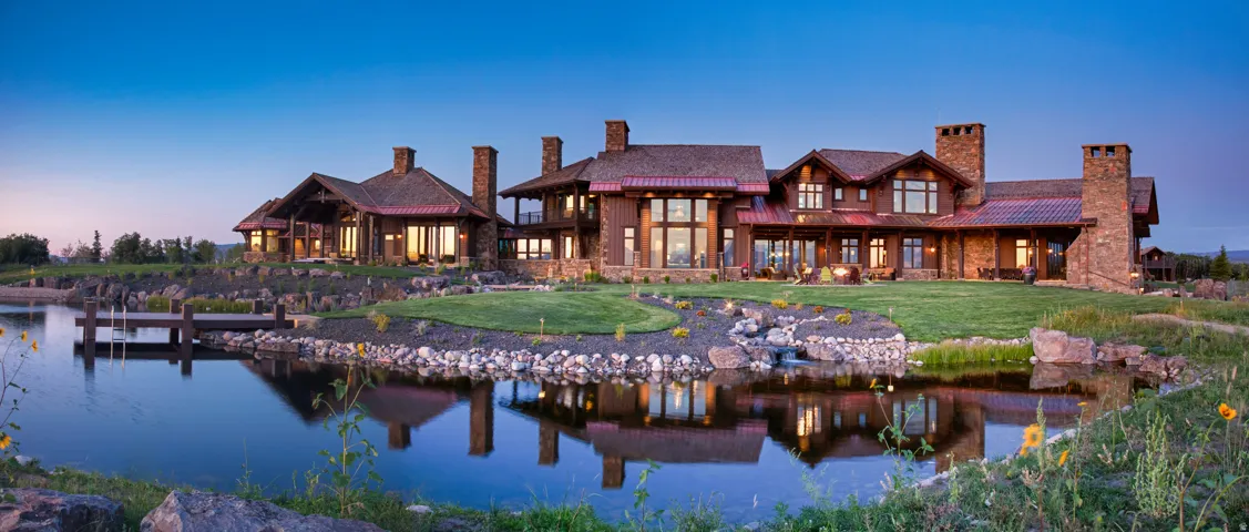 Back of property with a chimney, a water view, and a yard