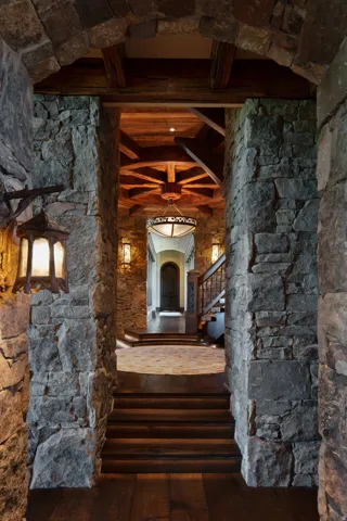 Corridor with arched walkways, dark wood finished floors, and beamed ceiling