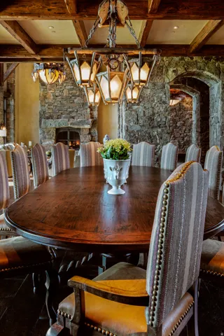 Dining room featuring a stone fireplace and coffered ceiling