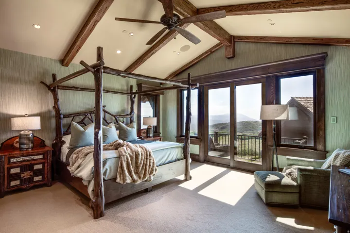 Bedroom featuring a mountain view, carpet flooring, access to outside, beam ceiling, and a ceiling fan