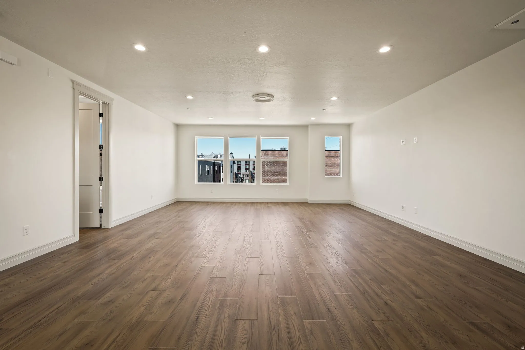 Spare room featuring dark wood-type flooring and recessed lighting
