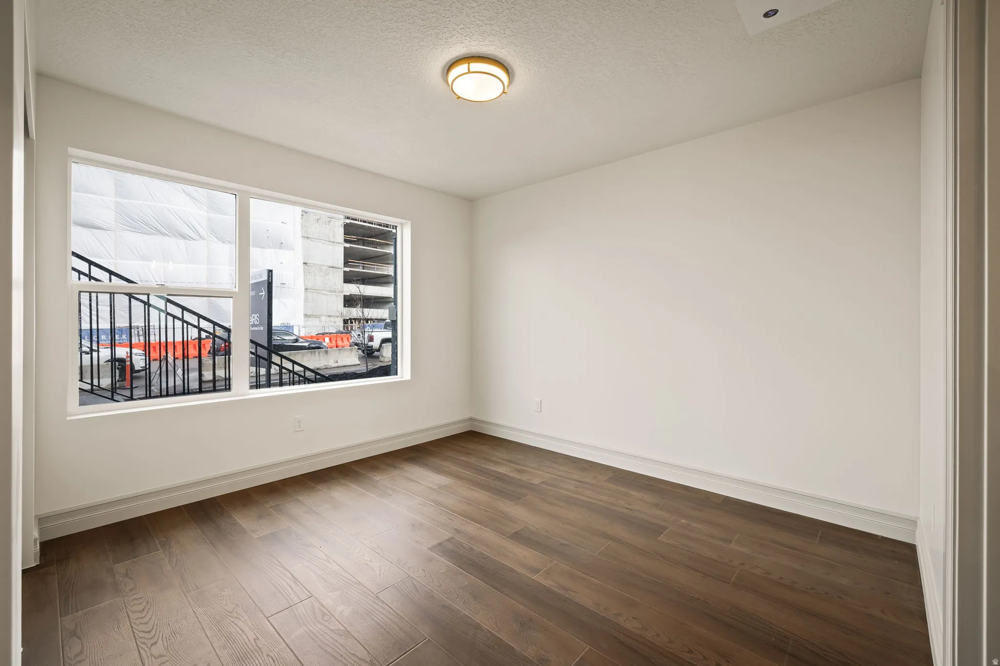 Spare room featuring a textured ceiling and dark wood finished floors