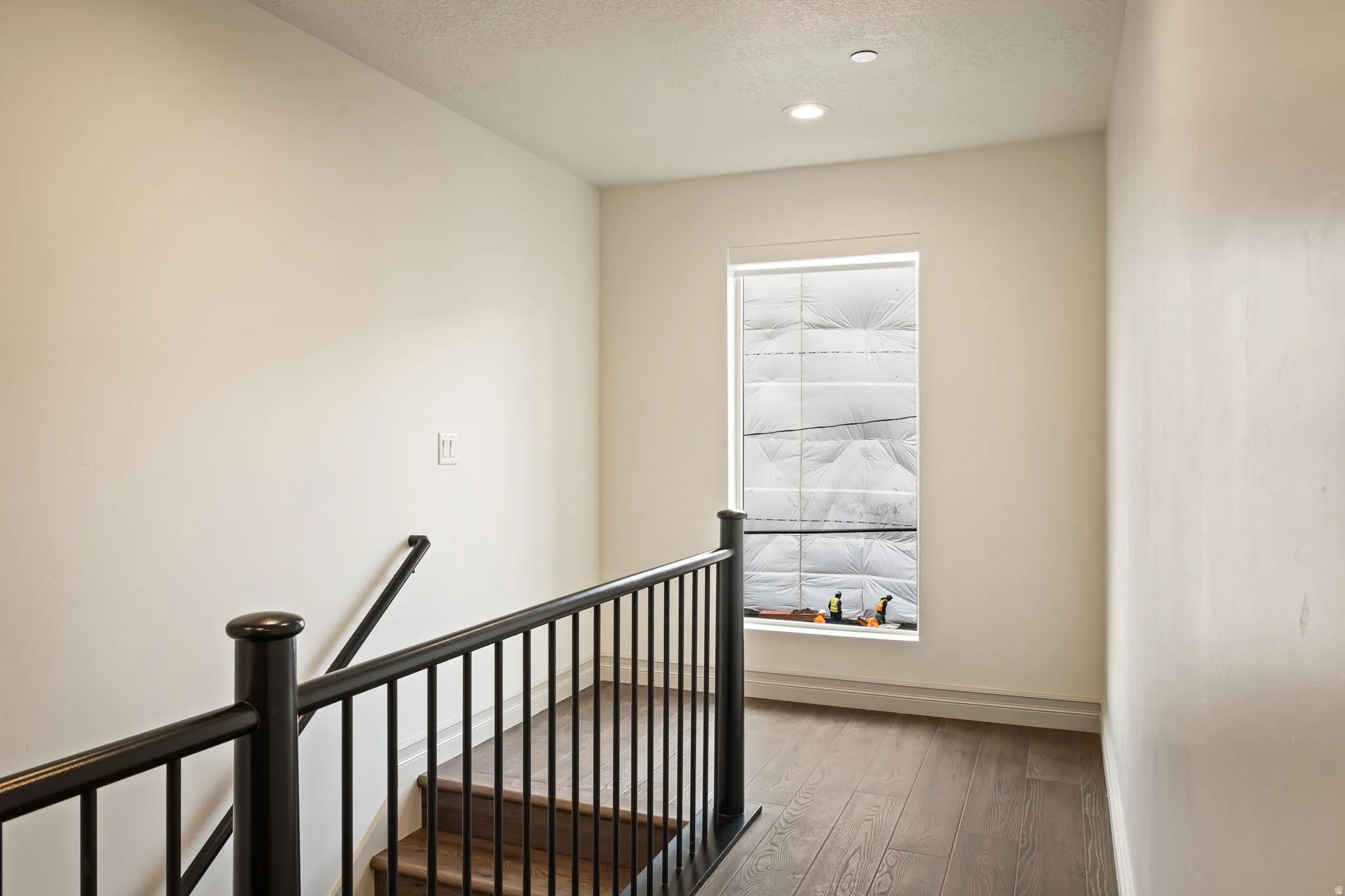 Corridor featuring an upstairs landing, hardwood / wood-style flooring, a textured ceiling, and recessed lighting