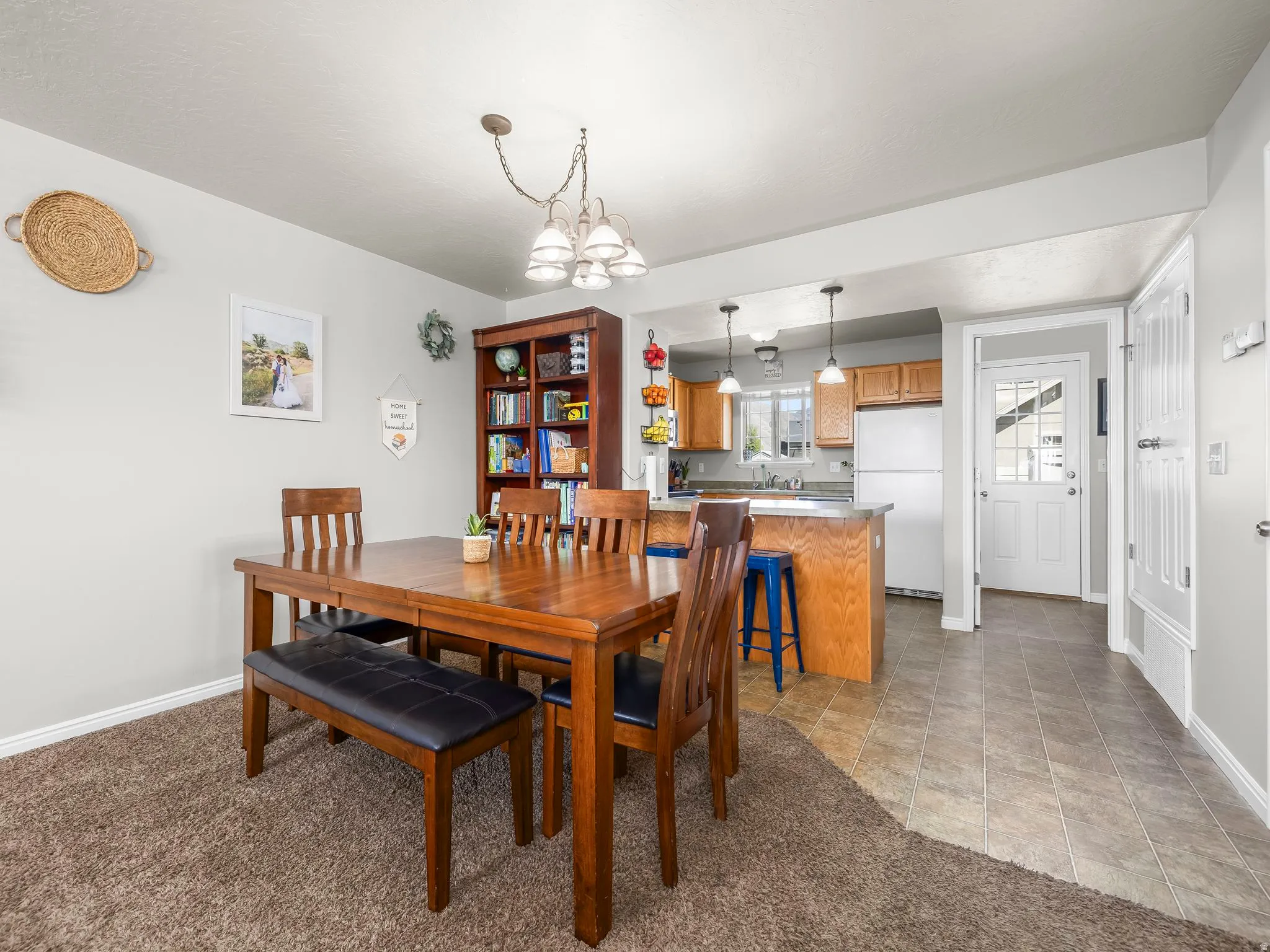 Dining space with hanging lights and light carpet