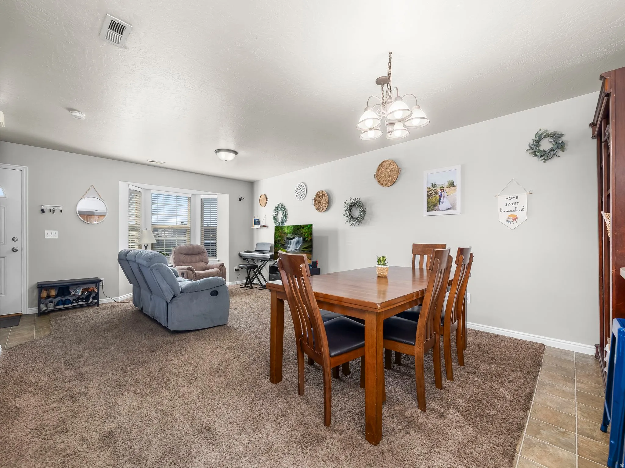 Tiled dining space with suspended lighting and a textured ceiling