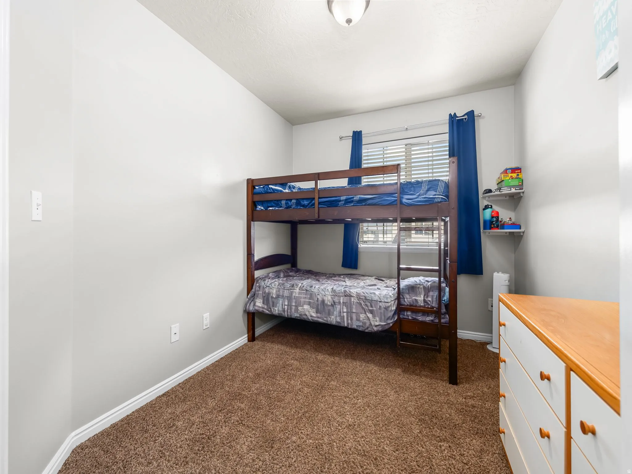 Bedroom featuring dark carpet and baseboards