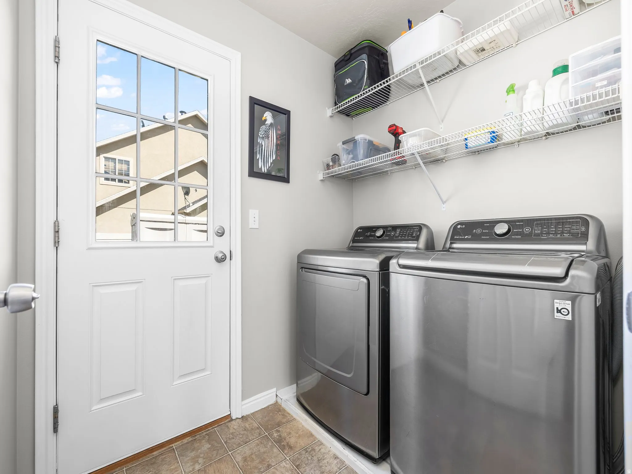 Laundry area with separate washer and dryer and light tile patterned floors