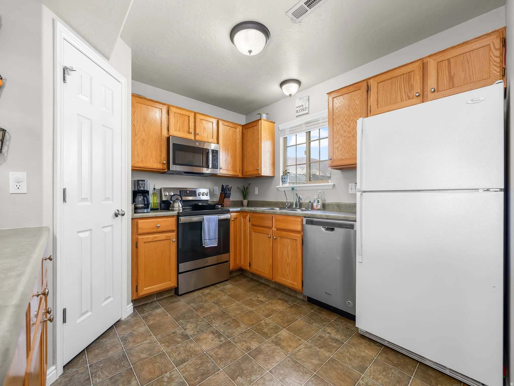 Kitchen with stainless steel appliances and stone finish flooring