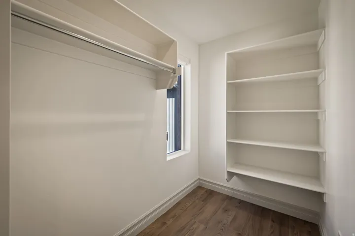 Walk in closet featuring dark wood-style flooring