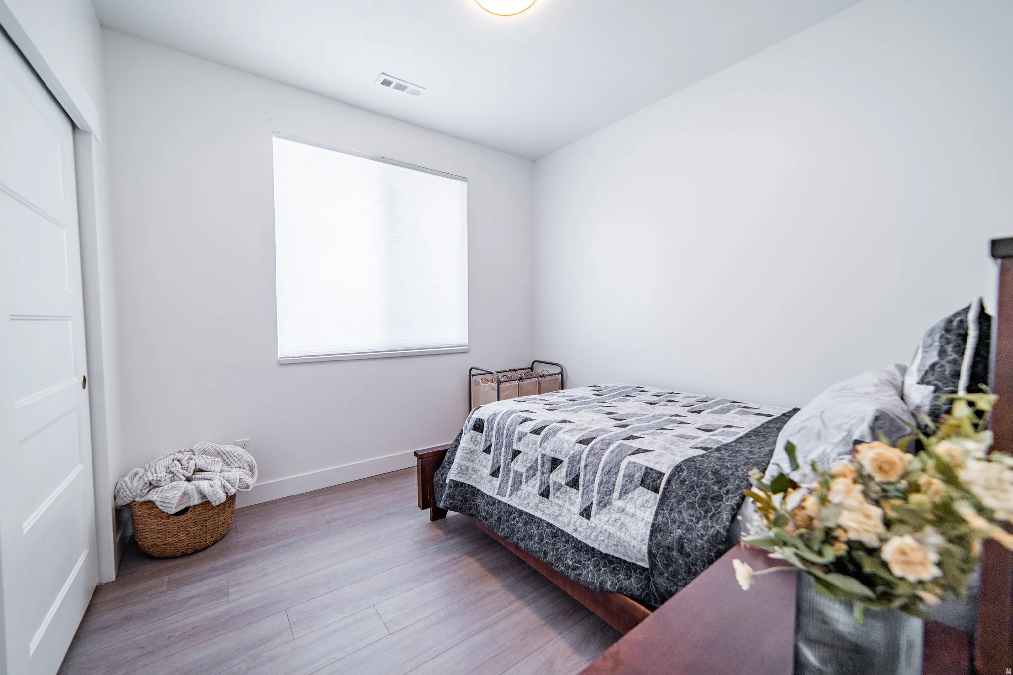 Bedroom with wood finished floors and a closet
