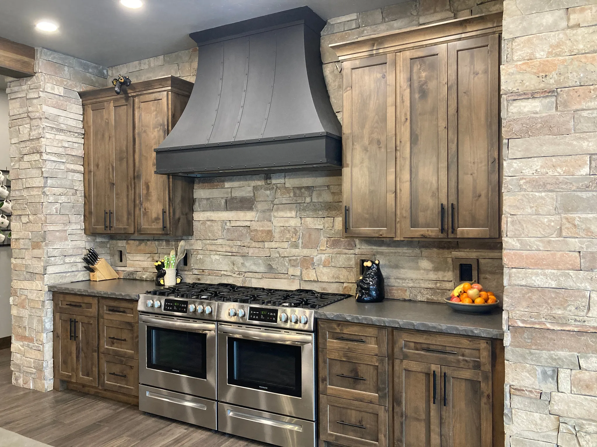 Kitchen with dark countertops, double oven range, dark wood-type flooring, and dark wood finish cabinetry