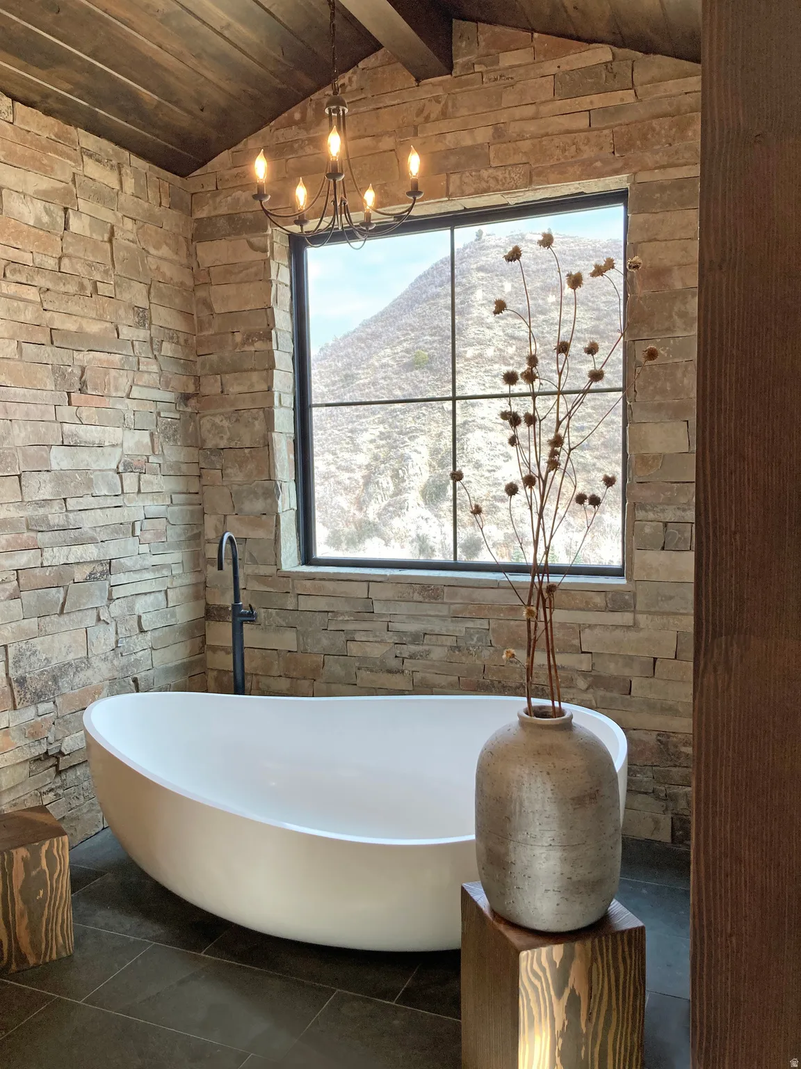 Bathroom featuring a wooden ceiling with exposed beams, a freestanding bath, and a mountain view