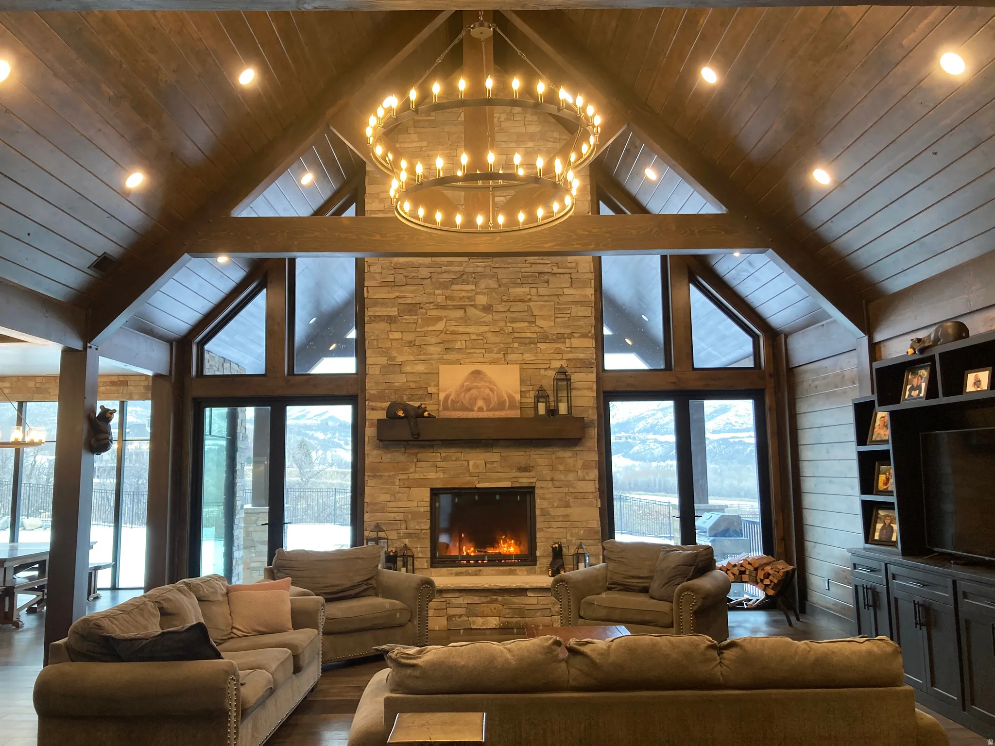 Living room with a fireplace, wood finished floors, a high wood ceiling, and a chandelier