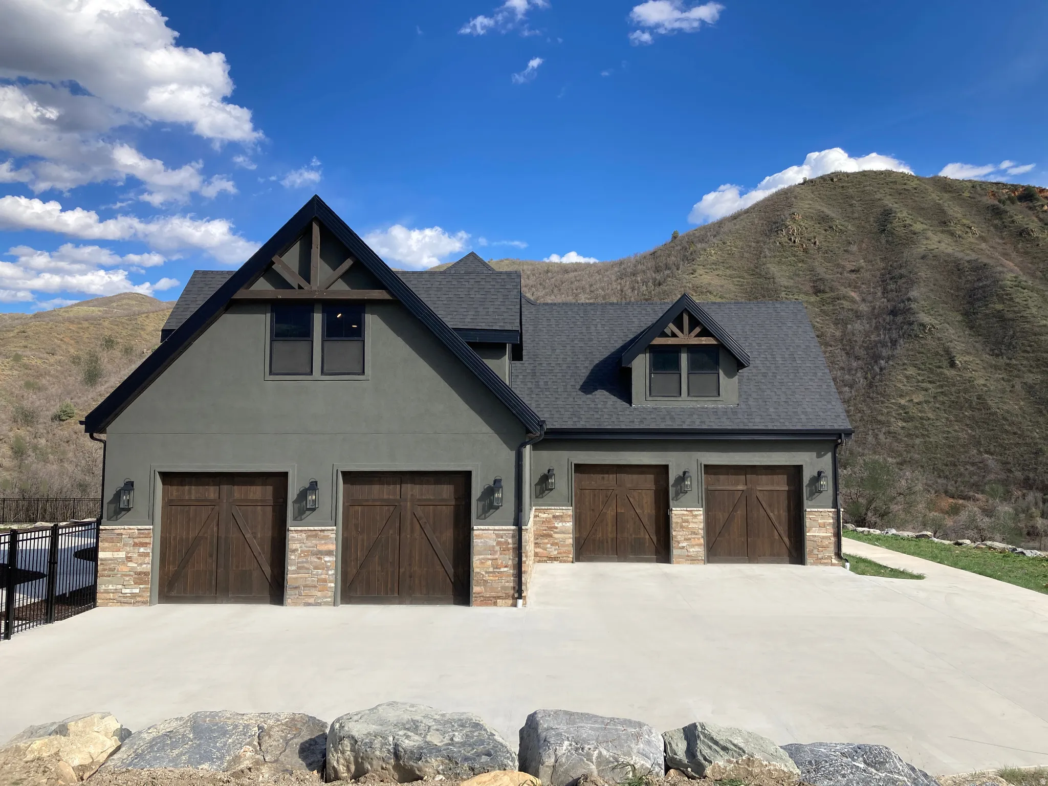 View of front of house featuring a mountain view, stone siding, and stucco siding