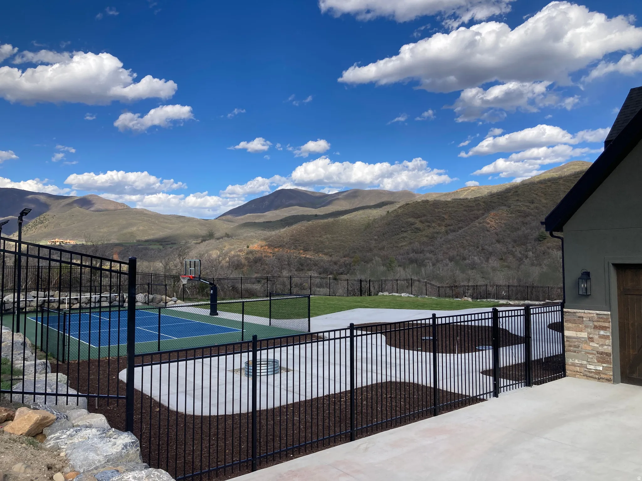 View of swimming pool featuring a mountain view, patio surround, and basketball hoop