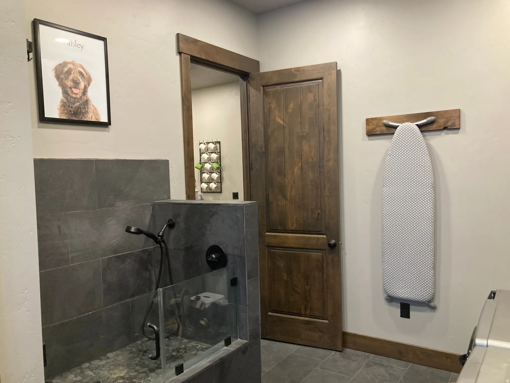 Bathroom featuring baseboards and dark tile patterned floors