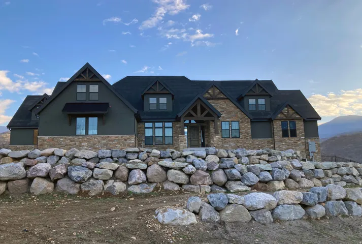 View of front of home featuring stucco siding, stone siding, and a mountain view