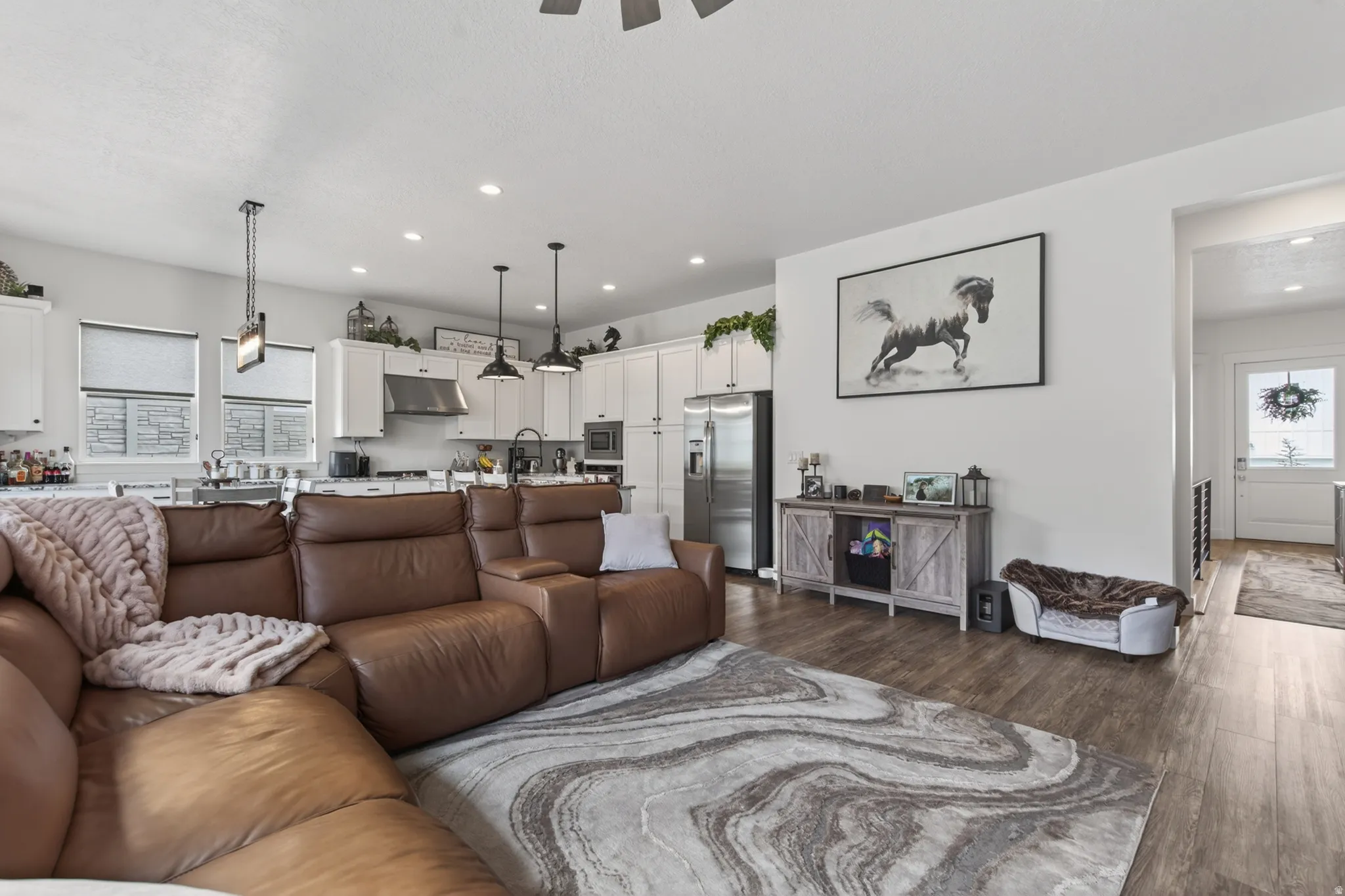 Living area featuring dark wood finished floors, ceiling fan, and recessed lighting
