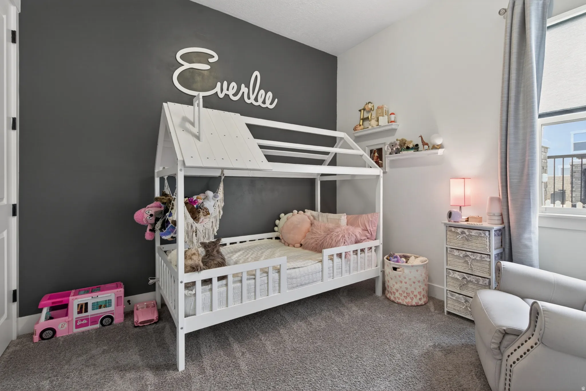 Bedroom with dark colored carpet and a crib